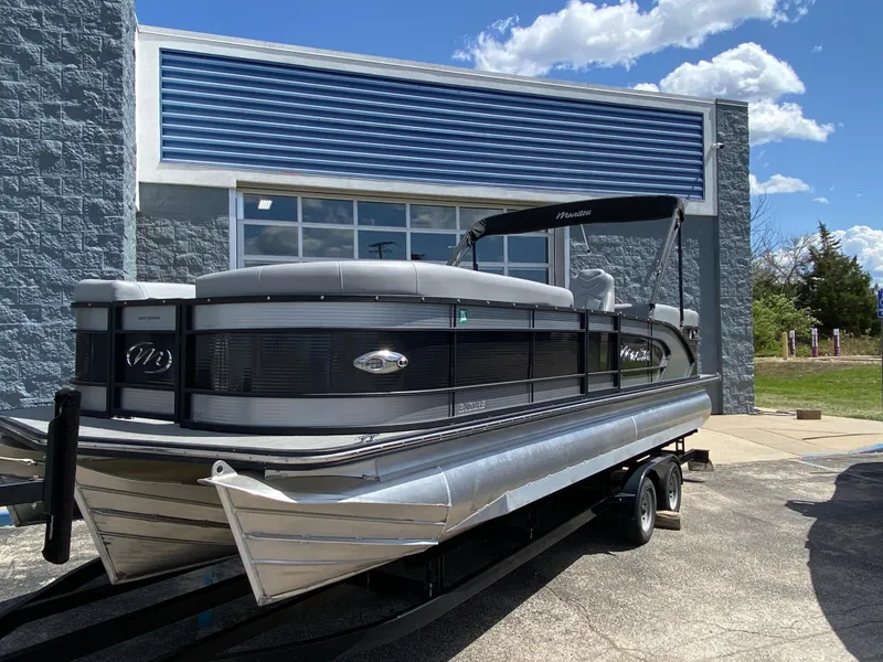 Slide: The Image of 2021 Manitou 25 Encore RF SHP Twin pontoon boat on trailer, parked outside a building. - 22