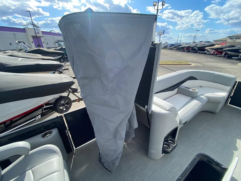 Slide: The Image of 2021 Manitou 25 Encore RF SHP Twin pontoon boat interior with seating and privacy curtain. - 23