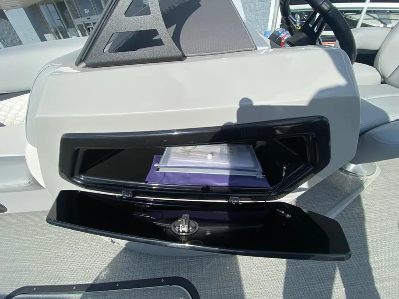 Slide: The Image of 2021 Manitou 25 Encore RF SHP Twin dashboard storage compartment open, revealing interior. - 31