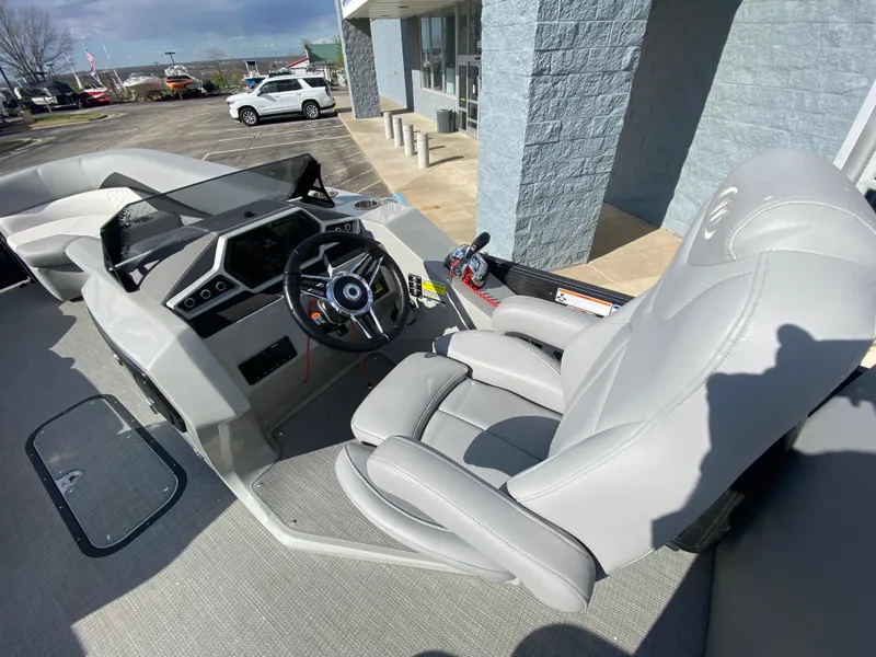 Slide: The Image of 2021 Manitou 25 Encore RF SHP Twin boat interior with steering wheel and captain's chair. - 32