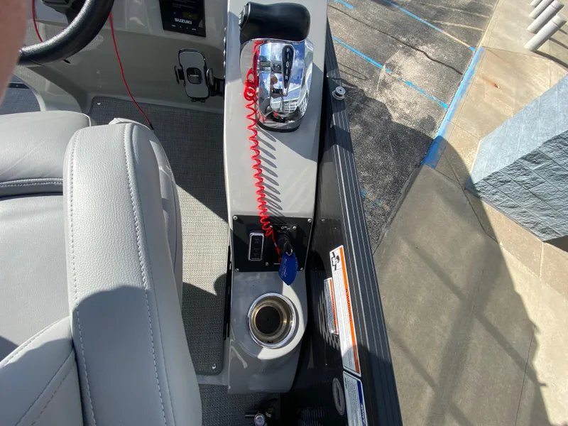 Slide: The Image of Control panel of 2021 Manitou 25 Encore RF SHP Twin boat with throttle and cup holder. - 37