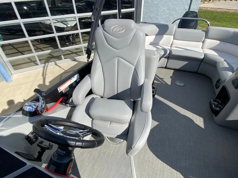 Slide: The Image of 2021 Manitou 25 Encore RF SHP Twin boat interior with captain's chair and steering wheel. - 39