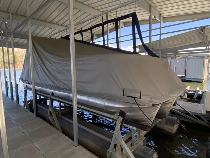 Slide: The Image of 2021 Manitou 25 Encore RF SHP Twin pontoon boat covered in dock. - 48