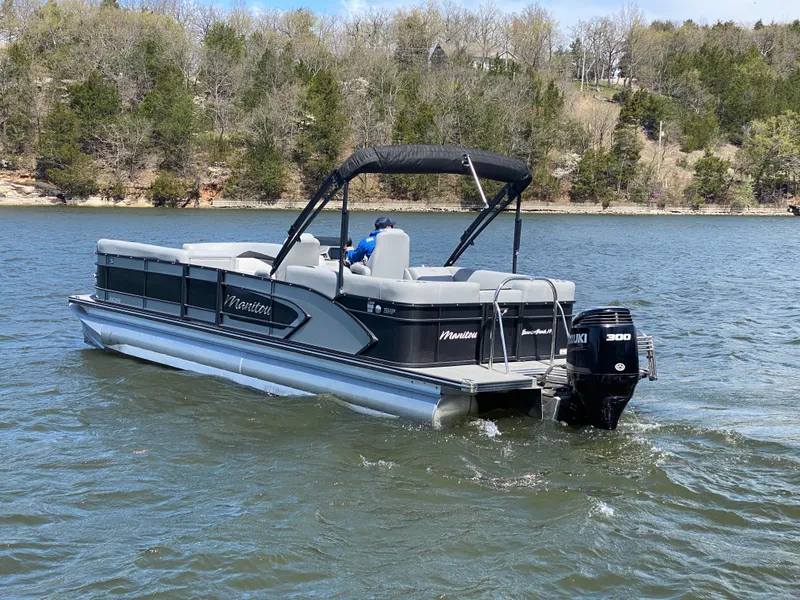 Slide: The Image of 2021 Manitou 25 Encore RF SHP Twin pontoon boat cruising on a lake. - 6