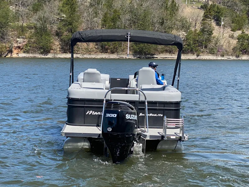 Slide: The Image of 2021 Manitou 25 Encore RF SHP Twin pontoon boat on a lake with Suzuki engine. - 7