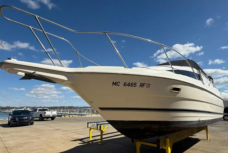 The Image of 1997 Bayliner 2655 Ciera Sunbridge boat on trailer under clear blue sky. - 0