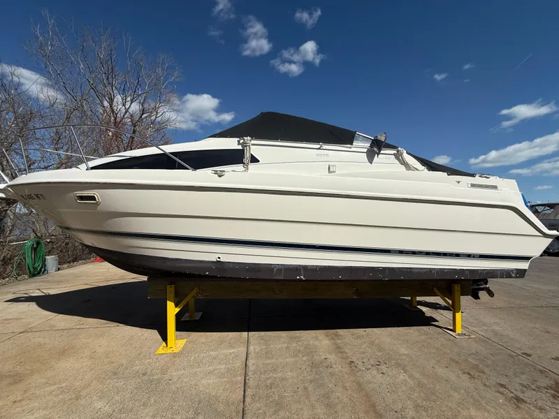 Slide: The Image of 1997 Bayliner 2655 Ciera Sunbridge boat on stands under a clear blue sky. - 1