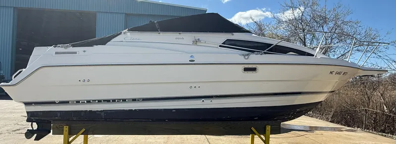 Slide: The Image of 1997 Bayliner 2655 Ciera Sunbridge boat on a stand, outdoors near a building. - 11