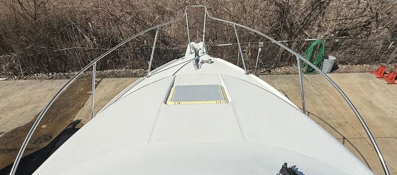 Slide: The Image of 1997 Bayliner 2655 Ciera Sunbridge boat deck, docked with visible railing and hatch. - 17