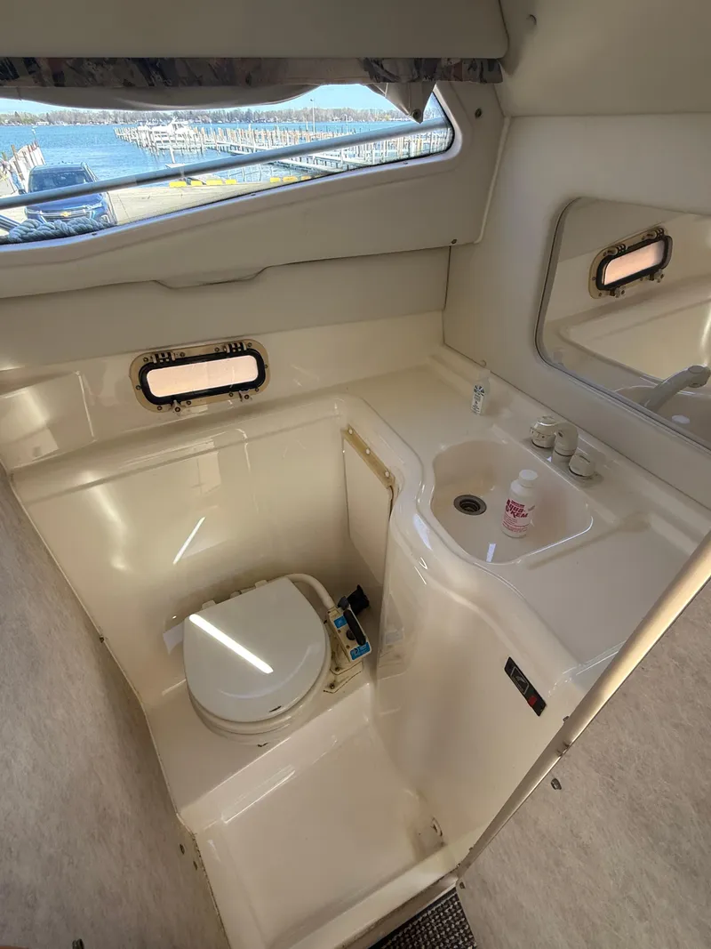 Slide: The Image of 1997 Bayliner 2655 Ciera Sunbridge bathroom with sink, toilet, and window view. - 26