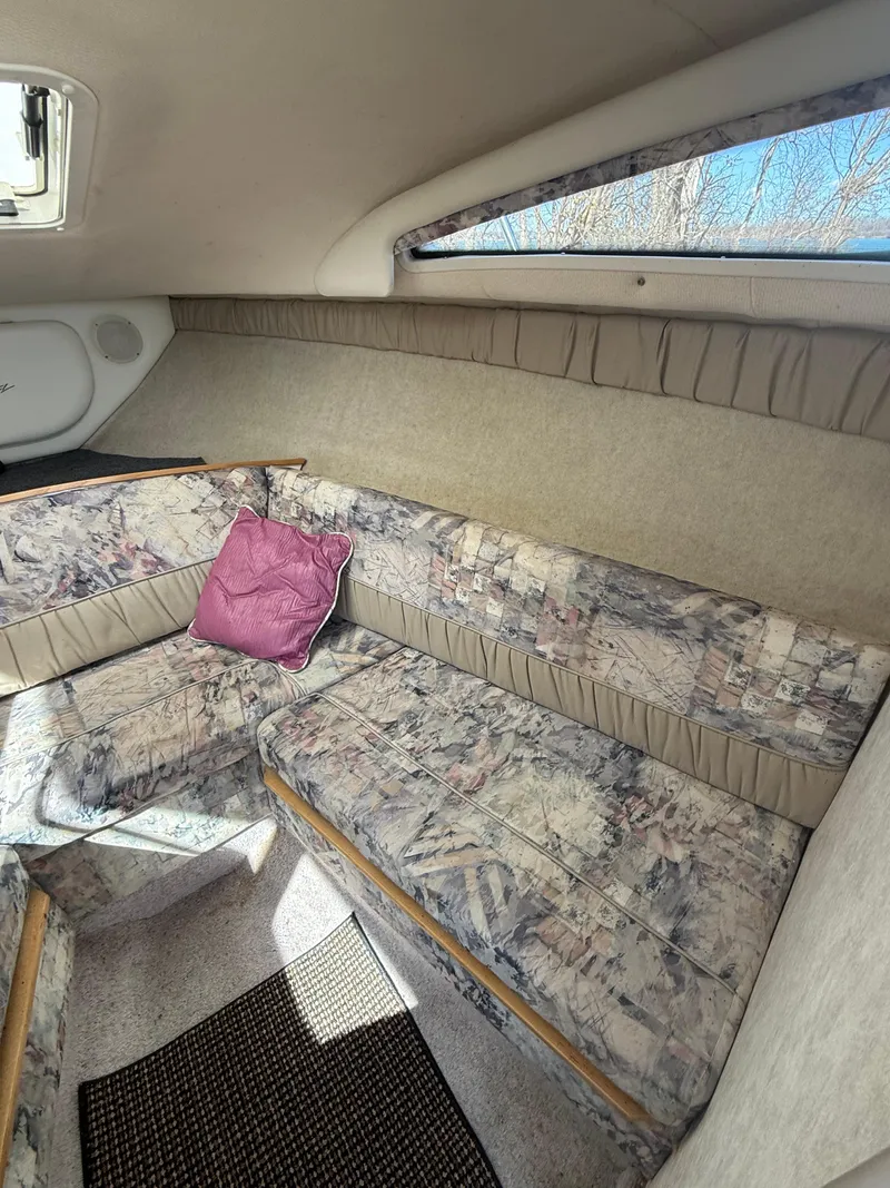 Slide: The Image of 1997 Bayliner 2655 Ciera Sunbridge cabin interior with patterned seating and a pink pillow. - 28