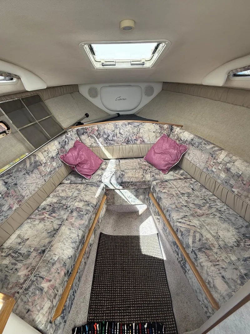 Slide: The Image of 1997 Bayliner 2655 Ciera Sunbridge cabin interior with patterned seating and pink cushions. - 29