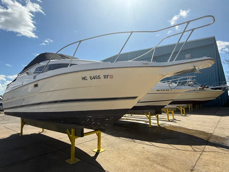 Slide: The Image of 1997 Bayliner 2655 Ciera Sunbridge boat on stands, sunny day, blue sky. - 3