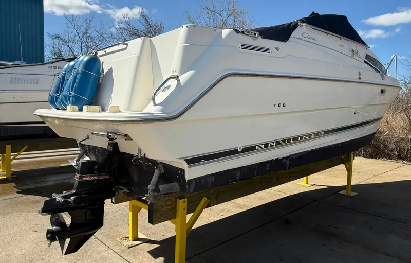Slide: The Image of 1997 Bayliner 2655 Ciera Sunbridge boat on stands, outdoor setting, sunny day. - 8