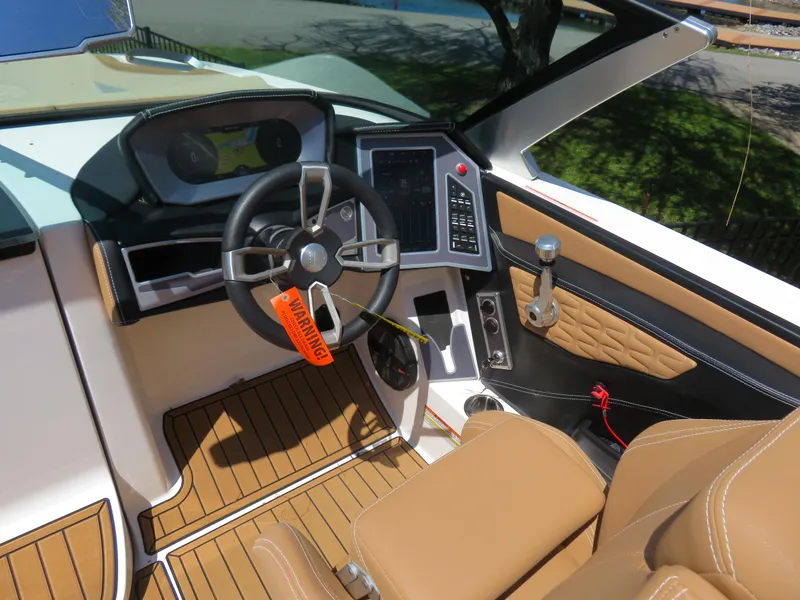 Slide: The Image of 2023 MasterCraft X26 boat cockpit with modern controls and tan seating. - 3