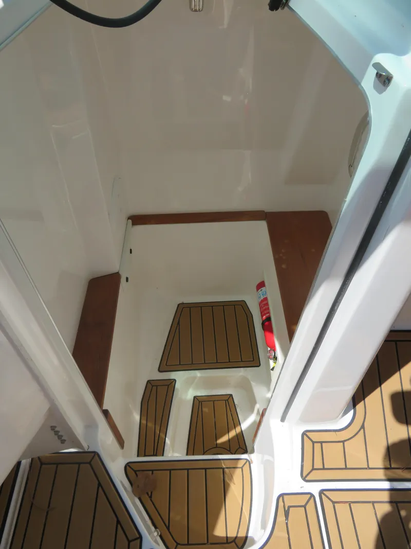 Slide: The Image of 2023 MasterCraft X26 boat interior with teak flooring and white walls. - 5