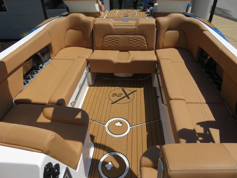 Slide: The Image of 2023 MasterCraft X26 boat interior with tan seating and teak flooring. - 7