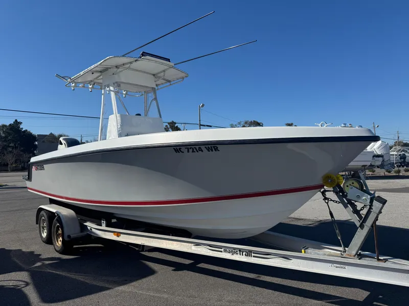 Slide: The Image of 2001 Contender 23 Open boat on trailer, side view, clear sky background. - 1