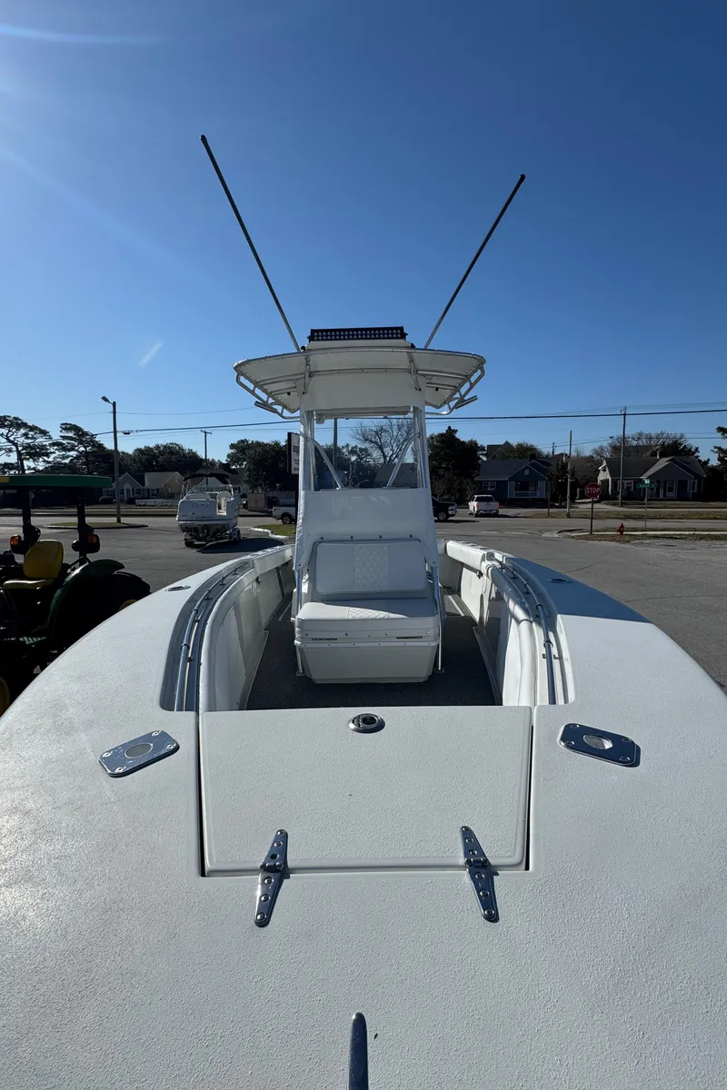 Slide: The Image of 2001 Contender 23 Open boat with center console and antennas, docked under clear blue sky. - 10