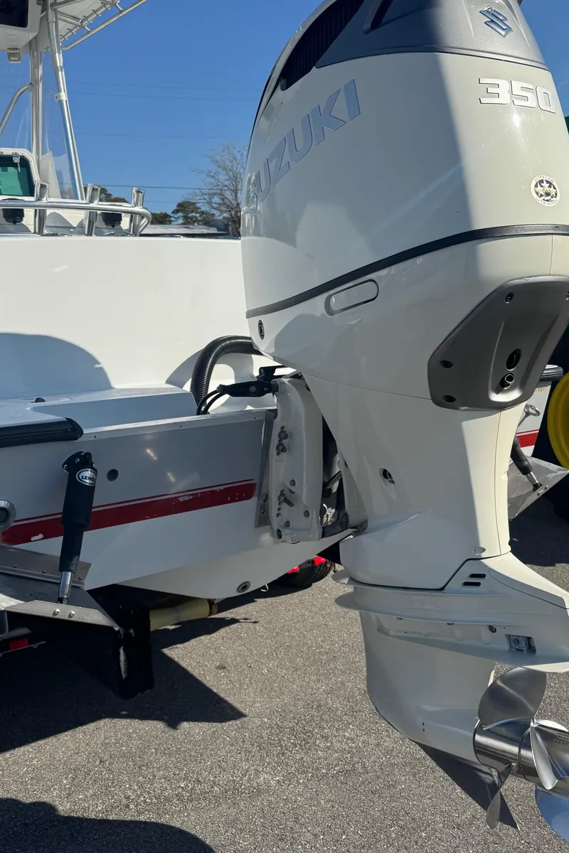 Slide: The Image of 2001 Contender 23 Open boat with Suzuki 350 outboard motor, parked on pavement. - 13