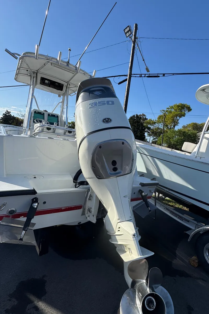 Slide: The Image of 2001 Contender 23 Open boat with outboard motor, docked under clear blue sky. - 14