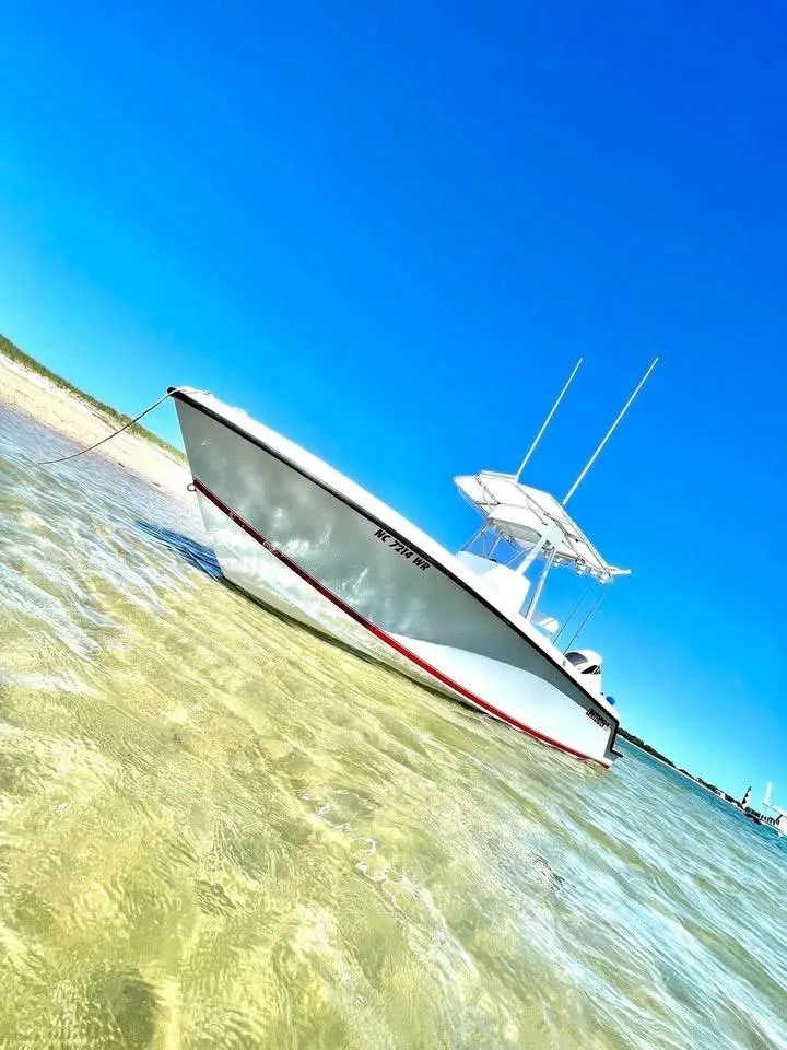 Slide: The Image of 2001 Contender 23 Open boat anchored in clear shallow water under a bright blue sky. - 16