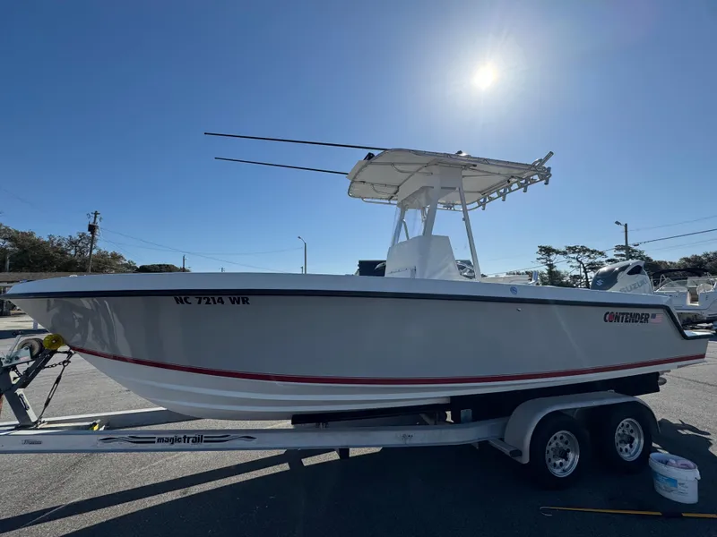 Slide: The Image of 2001 Contender 23 Open boat on trailer under bright sun. - 2