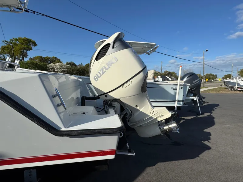 Slide: The Image of 2001 Contender 23 Open boat with Suzuki outboard motor, parked outdoors. - 4