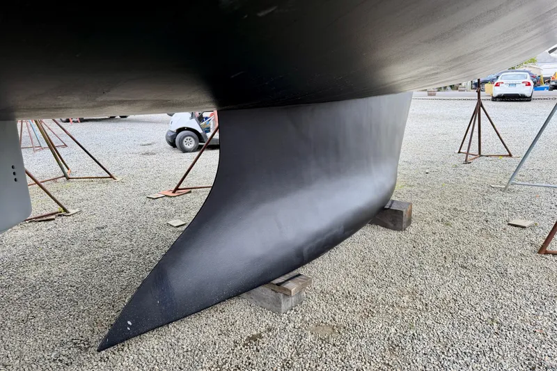 Slide: The Image of 2022 Elan Impression 50.1 yacht keel on gravel, supported by stands. - 108