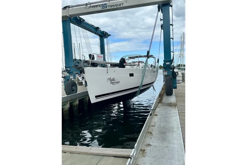 Slide: The Image of 2022 Elan Impression 50.1 yacht being lifted at a marina dock. - 109