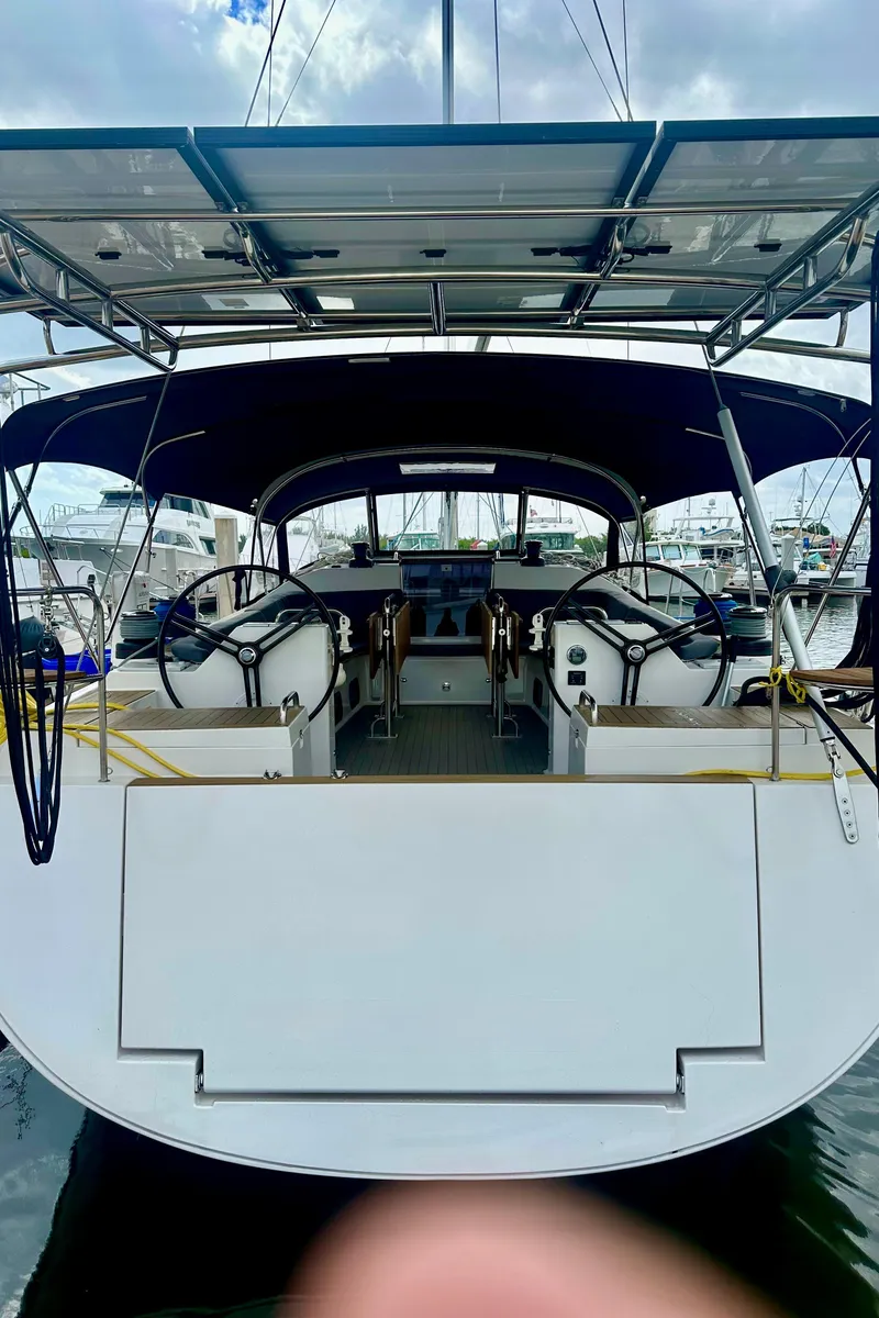 Slide: The Image of 2022 Elan Impression 50.1 yacht with dual steering wheels, docked at a marina. - 14