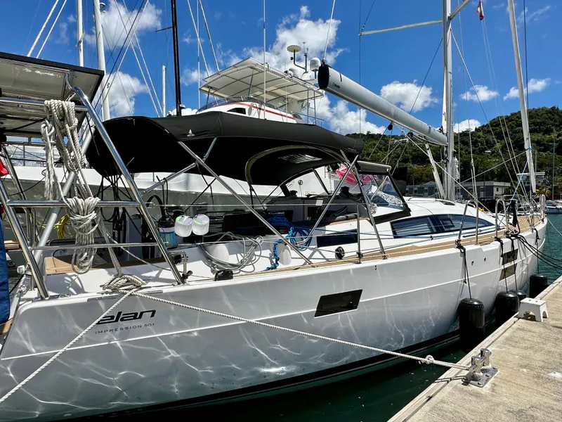 Slide: The Image of 2022 Elan Impression 50.1 yacht docked at marina under blue sky. - 2
