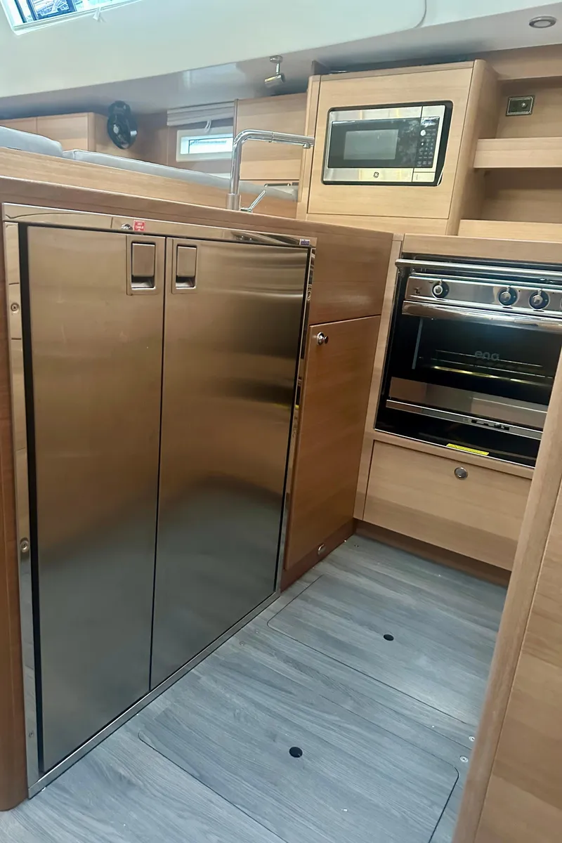 Slide: The Image of 2022 Elan Impression 50.1 yacht kitchen with stainless steel appliances and modern wood cabinetry. - 26