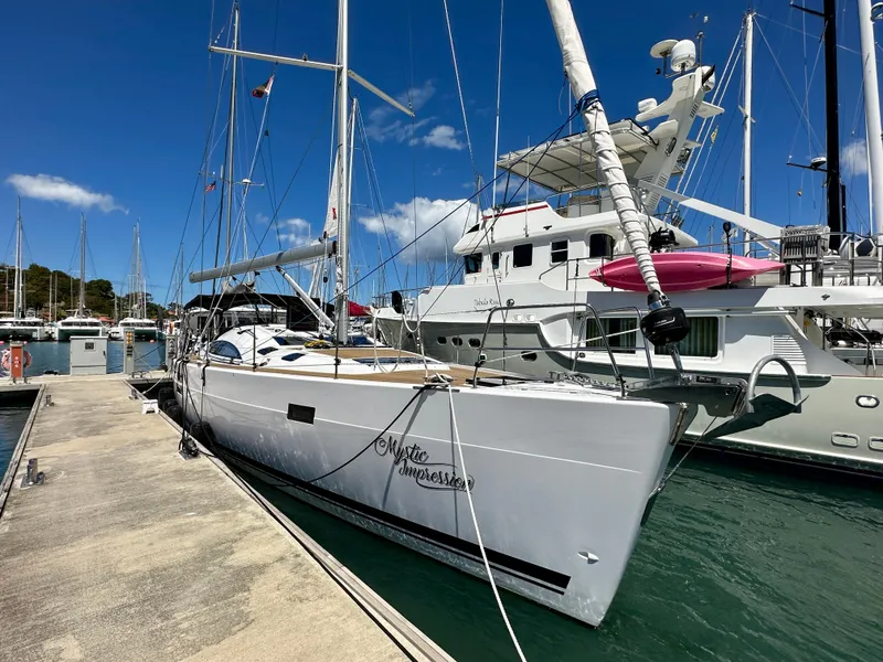 Slide: The Image of 2022 Elan Impression 50.1 yacht docked at marina under clear blue sky. - 3