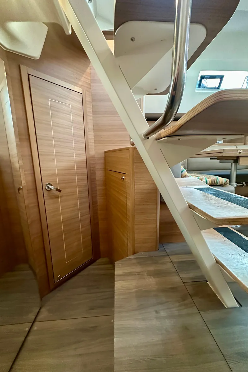 Slide: The Image of Interior of 2022 Elan Impression 50.1 yacht, featuring wooden stairs and door. - 40
