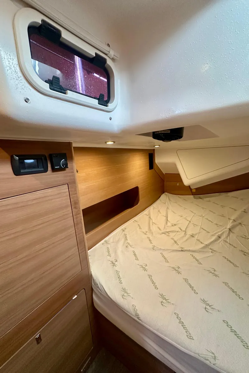 Slide: The Image of 2022 Elan Impression 50.1 yacht cabin with wooden interior and cozy bed. - 43