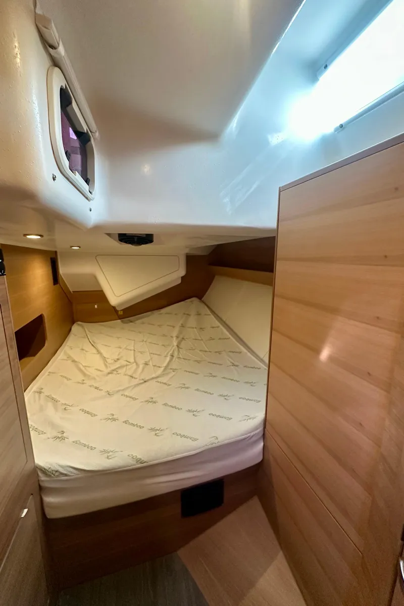 Slide: The Image of 2022 Elan Impression 50.1 yacht cabin with wooden interior and cozy bed. - 44