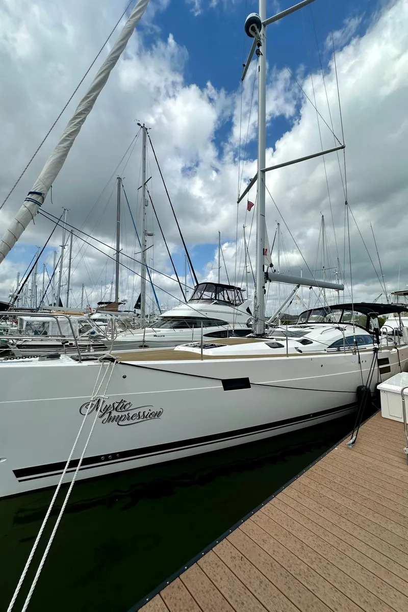 Slide: The Image of 2022 Elan Impression 50.1 yacht docked at marina under cloudy sky. - 7