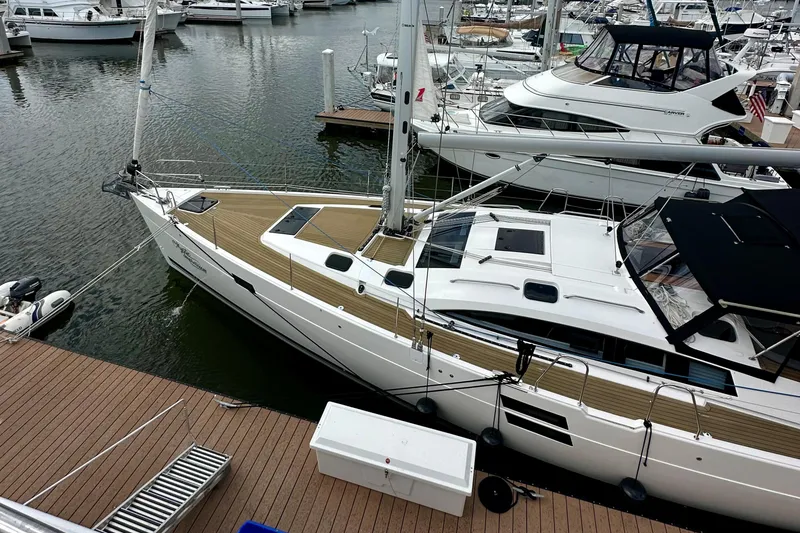 Slide: The Image of 2022 Elan Impression 50.1 yacht docked at marina, surrounded by other boats. - 8