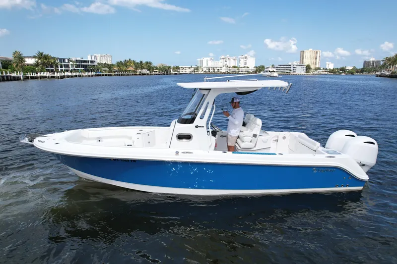The Image of 2023 Edgewater 262CC boat on calm water, featuring a sleek blue and white design. - 0
