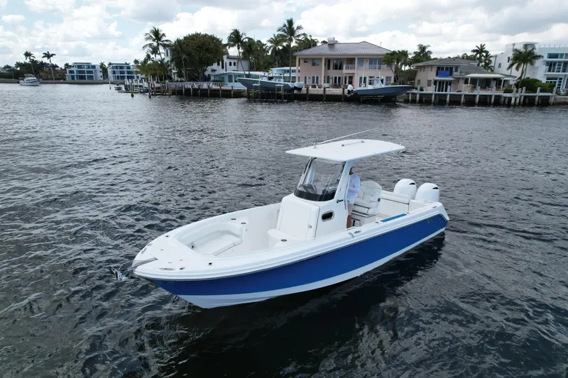 Slide: The Image of 2023 Edgewater 262CC boat on calm water near waterfront homes. - 1