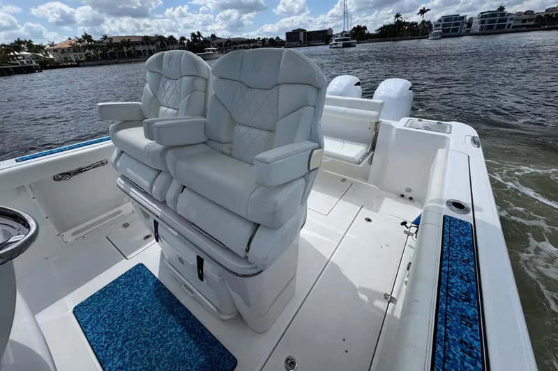 Slide: The Image of 2023 Edgewater 262CC boat interior with luxurious seating on a calm waterfront. - 12