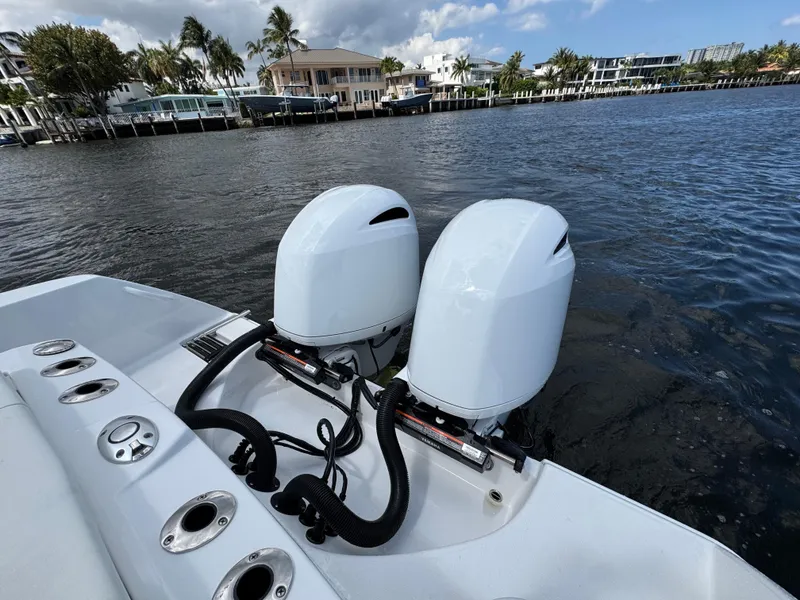 Slide: The Image of 2023 Edgewater 262CC boat with dual outboard engines on a calm waterfront. - 16