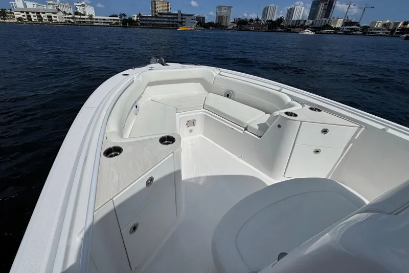 Slide: The Image of 2023 Edgewater 262CC boat interior with seating, cup holders, and city skyline in the background. - 17
