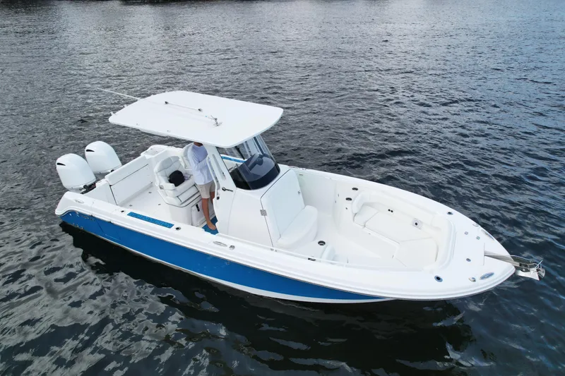 Slide: The Image of 2023 Edgewater 262CC boat on water, featuring dual engines and sleek design. - 2