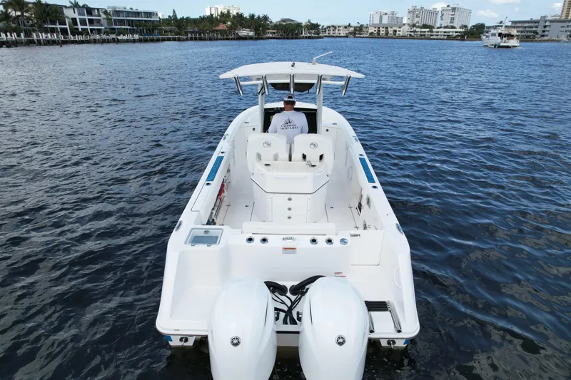 Slide: The Image of 2023 Edgewater 262CC boat on water, rear view with dual engines. - 5