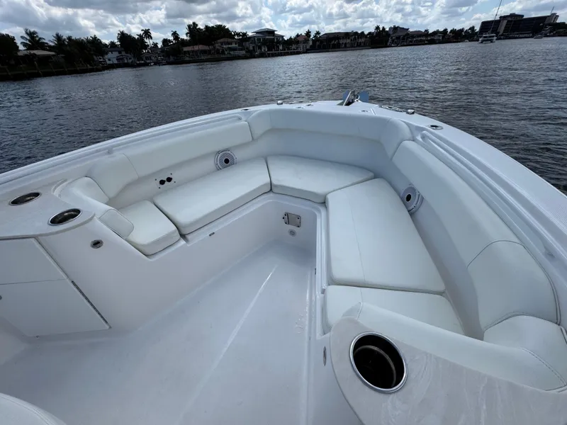 Slide: The Image of 2023 Edgewater 262CC boat interior with white seating, cup holders, and waterfront view. - 8