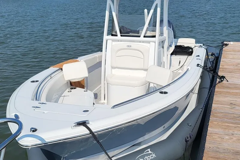 Slide: The Image of 2025 Center Console Eco dry dock boat moored at a wooden dock on calm water. - 13