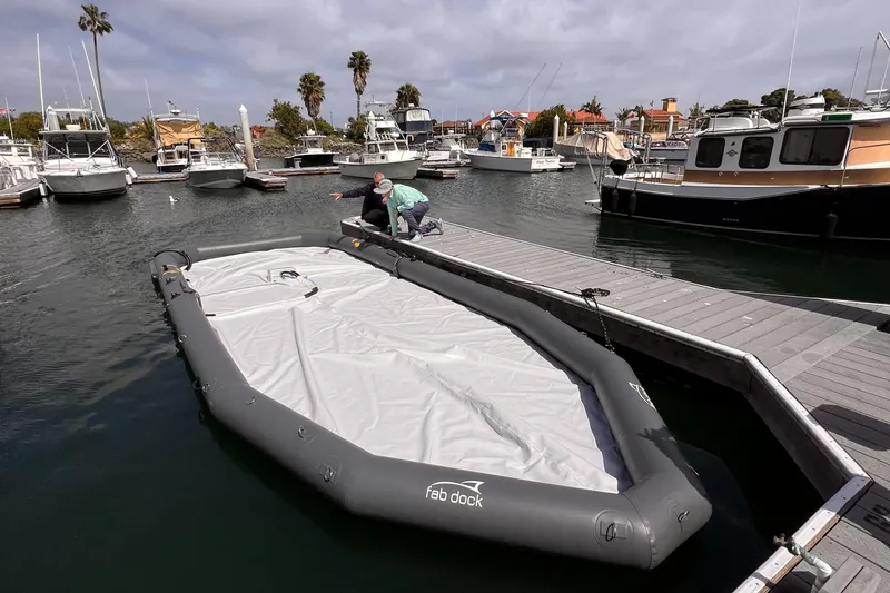 Slide: The Image of Inflatable Eco dry dock by Center Console, 2025, in marina with boats and dock. - 9