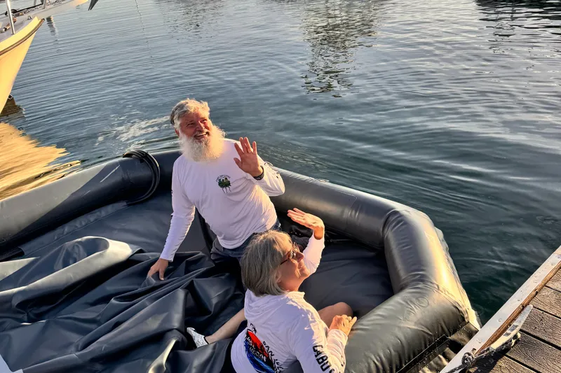 Slide: The Image of Two people waving from a 2025 Center Console Eco dry dock on the water. - 10